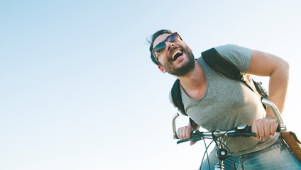 Active sport man with excited face expression exploring and traveling by mountain bike on the road....