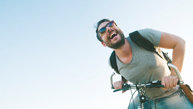 Active Sport Man With Excited Face Expression Exploring And Traveling By Mountain Bike On The Road. Vintage Film Filter Style Image.