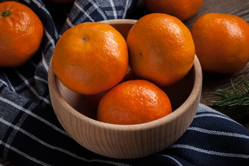 Fresh oranges in wooden bowl.