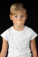 Naklejka premium little blond boy with plaster on his mouth looks sad