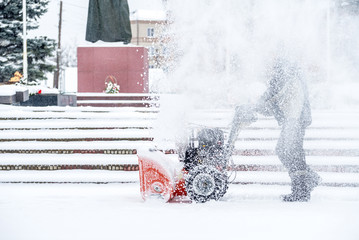 Snow-removal work with a snow blower. Man Removing Snow. heavy precipitation and snow pile