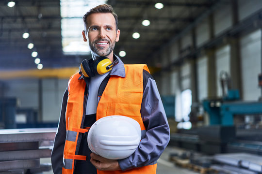 Portrait of smiling man wearing protective workwear in factory