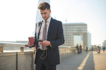 Businessman having a call while walking in the street