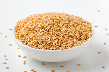 Golden flaxseed in bowl on white background