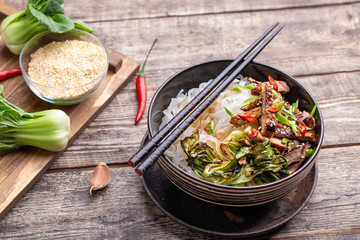 Spicy rice noodles wok with pork and bok choy