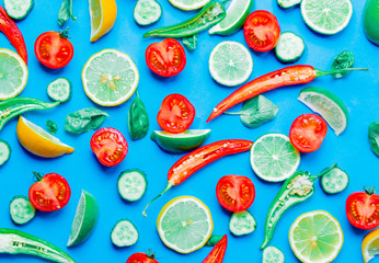 Above view at Chili pepper and cytrus with tomatoes and basil on blue background