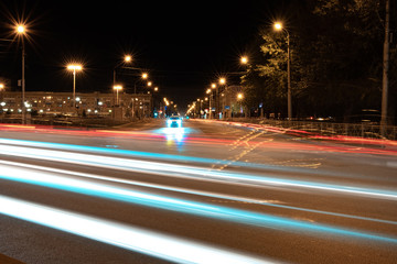 night city and traces of passing cars glowing lines from the headlights, in the background red glowing lines