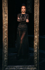 Naklejka premium gorgeous sexy woman with dark hair in luxurious lace dress posing in theater interior