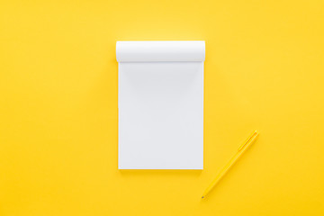top view of blank notebook on yellow background