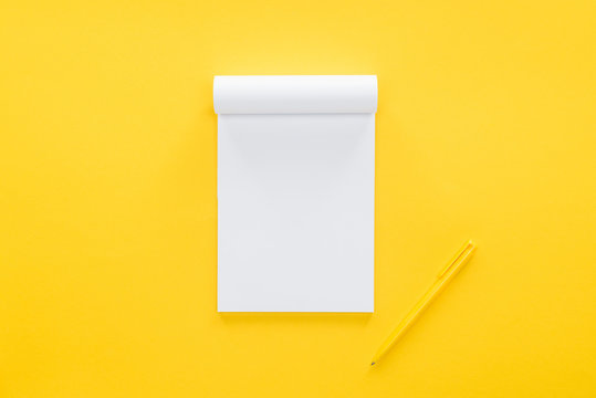 top view of blank notebook on yellow background