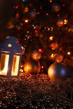 Christmas tree and golden beads. Selective focus. Golden holiday decorations. Dark photo.
