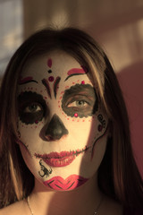 A girl with make-up skeleton on her face. Halloween.