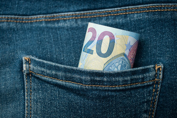 closeup of twenty euros banknotes in blue jeans pocket