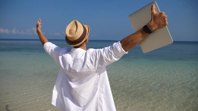 Business Man With Arms Outstretched Holding Laptop Enjoying Beach Holidays