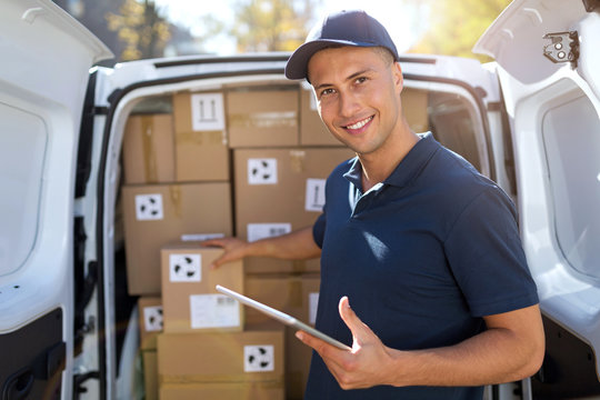 Delivery man standing in front of his van