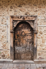Fototapeta na wymiar Beautiful old wooden brown door with handle in ancient city of Antalya city, Turkey. Vertical color photography.