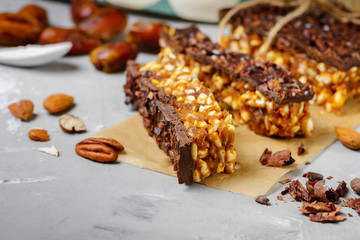 Raw vegan energy bars with dates and nuts and chocolate frosting. Homemade healthy snack sweets.