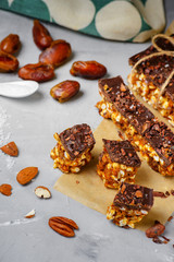 Raw vegan energy bars with dates and nuts and chocolate frosting. Homemade healthy snack sweets.