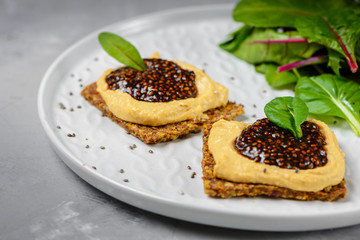Vegan caviar made with chia seeds and nori. Appetizers on whole grain crispbreads  with hummus