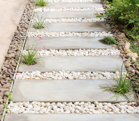 Landscape modern simple stone pathway in garden decoration with white,brown pebbles  and pink rain lily flowers