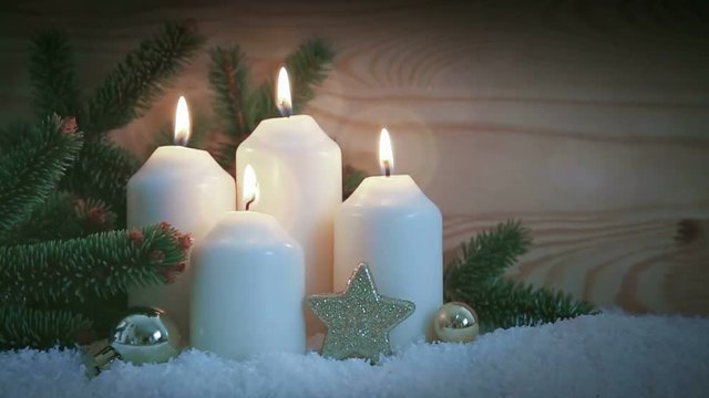 Christmas decoration and four burning Advent candles.
