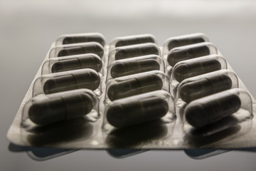 background. 15 pills packed in a silver blister