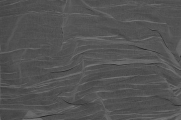 Thin dark grey fabric folded by waves