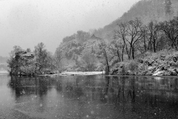 Falling snow creates a pointilistic effect. The Mohawk River funnels through a steep gorge in Little Falls, Herkimer County, New York State, USA.