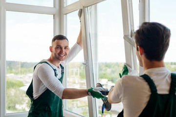 Handsome worker installing a window