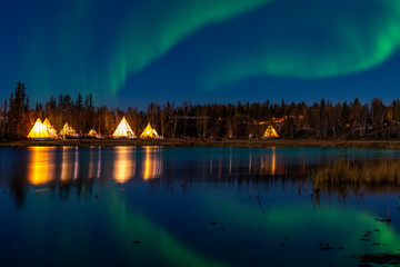 Light up Tipi (indian Tent) with water reflection during Aurora Borealis (Northern Light) at Yellow Knife,