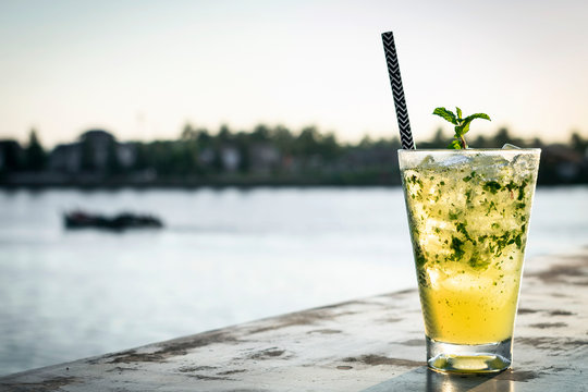 Orange Mojito Summer Cocktail Drink In Outdoor Riverside Bar