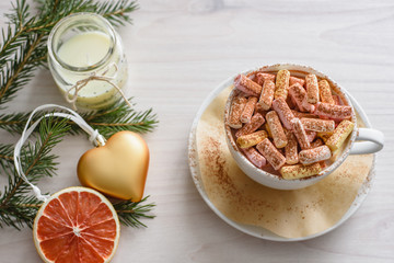 Christmas still life a cup of coffee, a souffle, a golden Christmas ornament in the shape of a heart, a fir branch and a grapefruit slice, a decorative candle on a wooden background