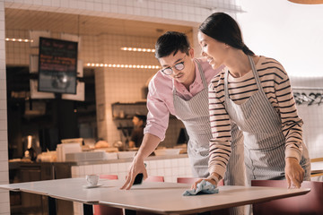 Manager wearing glasses giving some instructions to waitress
