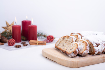 Christstollen auf einem Brett neben Weihnachtsdekoration