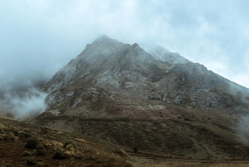 moody gray gloomy mountain landscape with a rocky ridge among the clouds