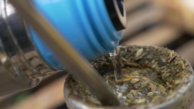 Flusk pouring water in a mate