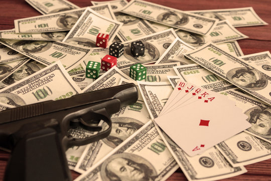 gun, dice, cards, American dollar bills. gambling, risk, excitement, danger.