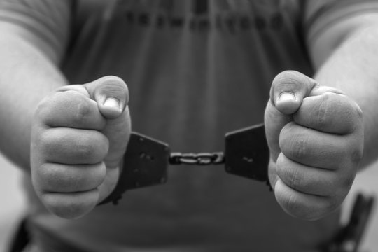 men's hands in handcuffs. arrest, detention of the criminal.