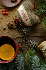 Details of still life in the living room home interior. Beautiful cup of tea with spices and sweaters on a wooden background. Cozy autumn-winter concept...