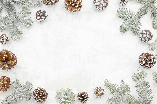 Christmas creative frame made of cones and fir branches on white background with free space for lettering. Winter concept. Flat lay. Top view.