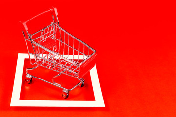 Red shopping cart and canvas on the red background.