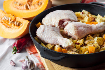 Cooking one-pot meal - chicken thighs and legs with potatoes and pumpkin