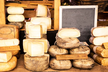 Assorted pieces of cheese for sale at a traditional market stall
