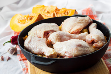 Cooking one-pot meal - chicken thighs and legs with potatoes and pumpkin