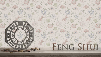 Fototapeta na wymiar Wooden vintage table shelf with ba gua and 3d letters making the word feng shui with abstract floral background with copy space, zen concept interior design