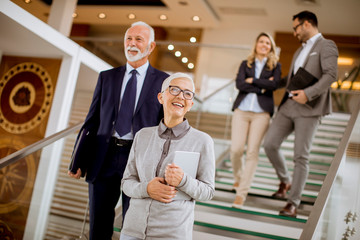 Businessmen and businesswomen walking and taking stairs in an office building