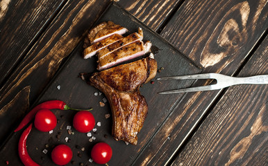Grilled New York steak with salt and pepper on a dark wooden background