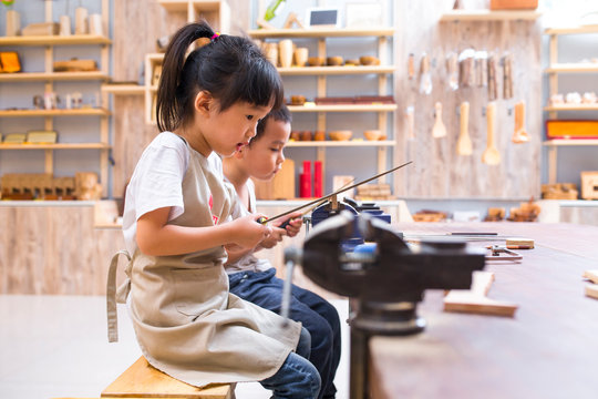 two asian kids doing carpenter job in the studio
