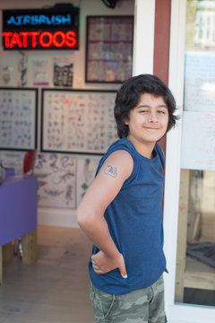 Proud guy of his first tattoo on the door of a local art brush tattoo