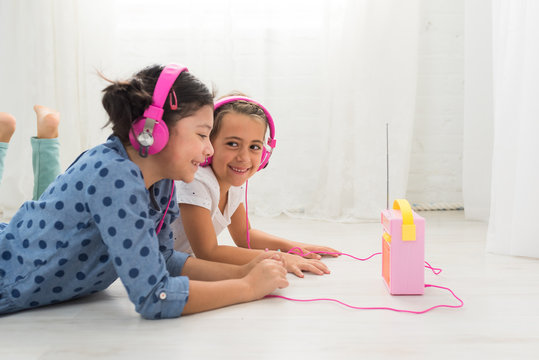 Two Girls Listening To A Radio With Headphones